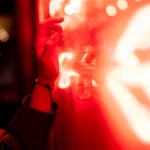 Arm und Hand einer Frau nahe einer roten LED-Beleuchtung
